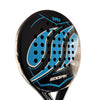 A close-up of a S.P.A.W. padel paddle head with a black, blue, and white graphic design, held by a hand against a beige wall.